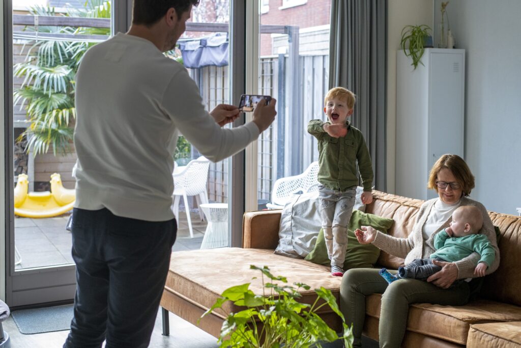 En pappa som fotograferar sin familj i ett hem med balanserad ventilation och värme