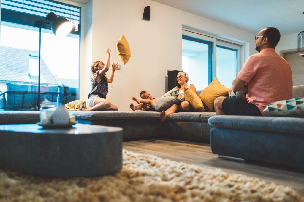 En familj som kopplar av i soffan i ett varmt och behagligt vardagsrum